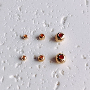 Dettaglio macro di perline rotonde in oro 14K con trama a spirale per gioielli