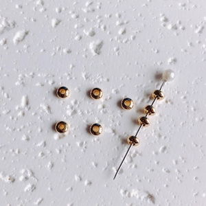 Macro detail view of 14K gold filled saucer spacer beads for jewelry making