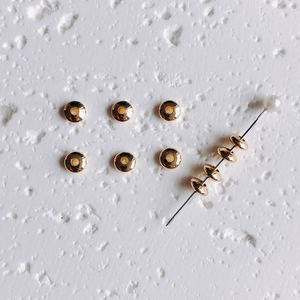 Detailed view of 14K gold-filled saucer spacer beads for DIY jewelry making and crafts