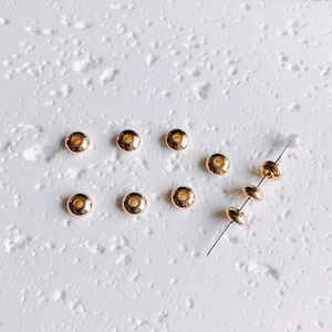 Macro shot of 14K gold filled spacer beads showing precise center hole for DIY jewelry