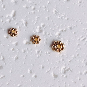 Macro detail of 14K gold plated flower spacers for DIY jewelry making accessories