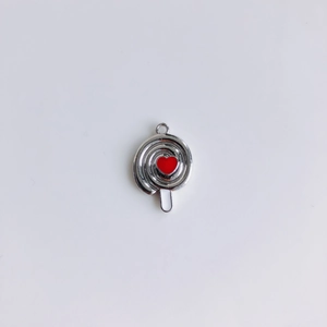 Dettaglio di un ciondolo a lecca-lecca argento con cuore rosso lucido e gancio superiore