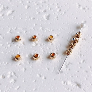 Vue macro de perles texturées en or 14K avec gravure en spirale pour bijoux DIY
