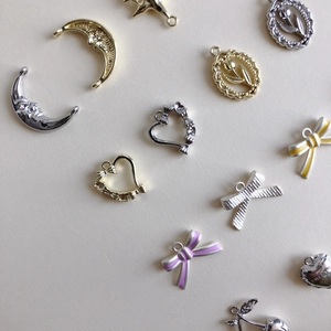 DIY jewelry charms in gold and silver featuring moon, heart and bow designs