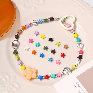 Colorful star bead pendant with sunflower charm and heart clasp on vintage ceramic plate