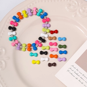 Detail van kleurrijke vlinderkralen van hars en een handgemaakte armband op een schaal