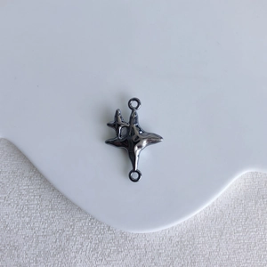 Detail view of gunmetal gray star-shaped jewelry connector with dual loops for DIY crafting