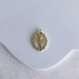 Detailed close-up of a vintage golden tulip embossed oval pendant for DIY jewelry