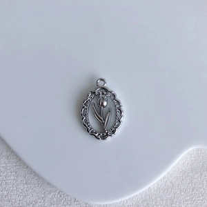 Close-up of silver tulip relief pendant with lace edges for DIY jewelry making