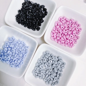 Macro view of assorted oval resin beads in matte pastel colors for DIY jewelry crafting