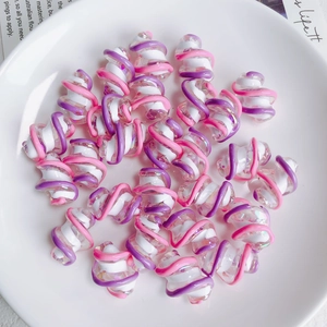 Macro-opname van kleurrijke spiraalvormige acryl kralen in wit roze en paars voor DIY