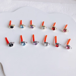 Detailed top view of 12 rhinestone earring studs in gold and silver alloy bases
