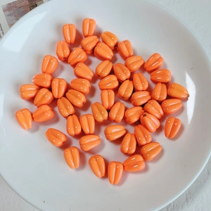Close-up of orange acrylic wheat grain beads for DIY jewelry and mobile chains