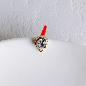 Close-up of gold-plated circular crystal stud finding with small connecting ring