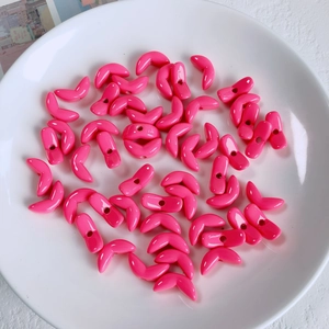 Close-up of glossy bright pink acrylic crescent moon beads for DIY jewelry making