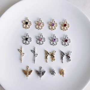 Détail d'une collection de breloques en alliage de cœur, papillon et croix avec cristaux