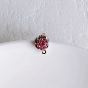 Macro detail of a pink round faceted crystal pendant with a silver DIY jewelry loop