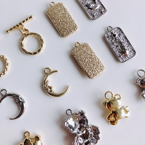 DIY jewelry charms set with gold and silver bears, moons and OT clasps on white background