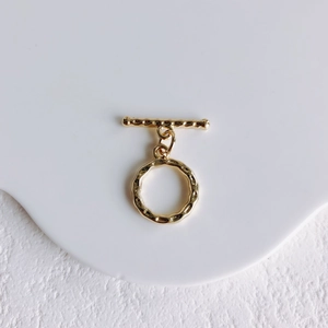 Detail view of golden moon-shaped toggle clasp with unique hammered texture for DIY jewelry