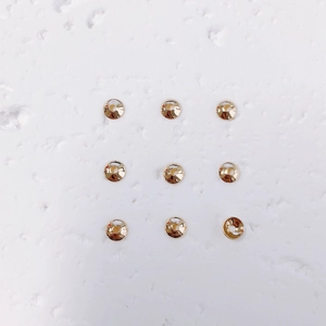 Macro detail of nine 18K gold-plated round bead spacers for jewelry making