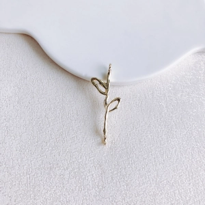 Détail macro d'un pendentif pétale de fleur papillon doré pour bijoux DIY