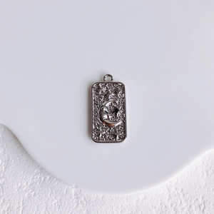 Detail of silver rectangle pendant with moon and star relief for DIY jewelry making