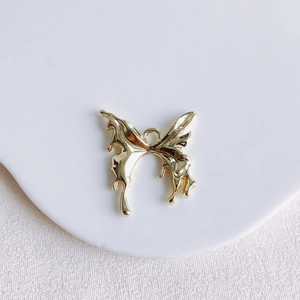 Vue détaillée d'un pendentif papillon doré fondant avec finition en métal liquide