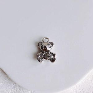 Detailed view of a silver polished bear pendant charm with loop for DIY jewelry making