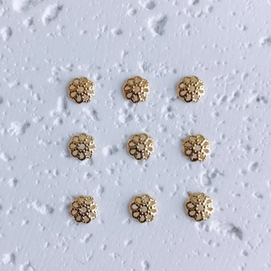 Macro view of six-petal hollow gold flower bead caps for DIY jewelry making