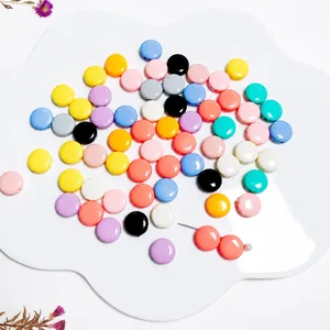 Cuentas redondas planas de acrílico en colores caramelo en bandeja para bricolaje