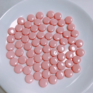 Primer plano de cuentas acrílicas rosas redondas y planas en un plato para manualidades