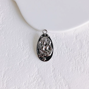 Macro detail of oval sun gold coin pendant with embossed figures and star patterns