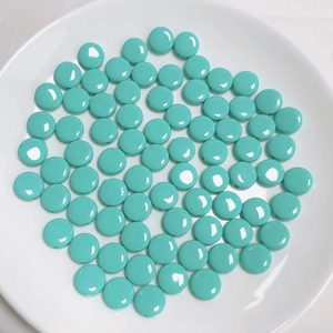 Cuentas redondas planas de acrílico turquesa con acabado brillante en plato blanco