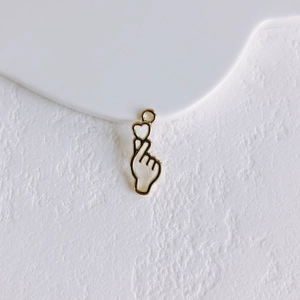 Macro shot of gold finger heart charm for DIY jewelry with polished metallic surface