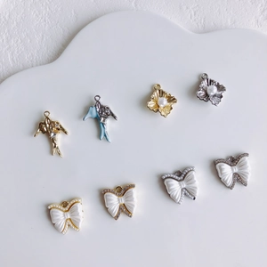 DIY sieraden bedeltjes set met zwaluw en strikjes met parels en strassteentjes op display