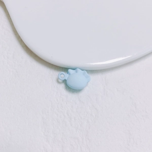 Vue macro de breloque en forme de raviole bleu clair avec boucle pour bijoux DIY
