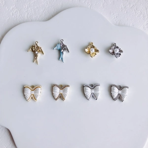 Detail van 8 blauwe zwaluw- en parelboogbedeltjes voor DIY-sieraden op een dienblad
