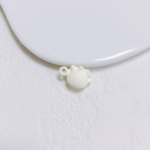 Gros plan d'un pendentif de boulette en résine blanche pour la création de bijoux DIY