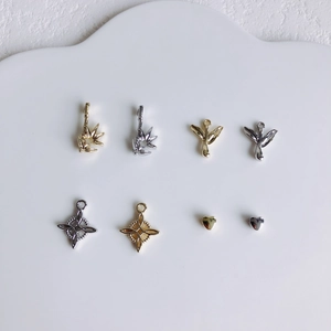 Vue détaillée de pendentifs DIY assortis en or et argent avec motifs cœurs et étoiles