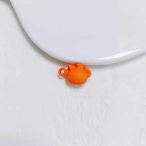 Vue détaillée d'une breloque orange en forme de gyoza pour la création de bijoux