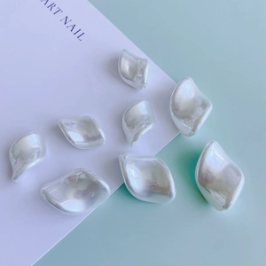 French vintage pearl earrings with irregular pearlescent finish on a soft blue background