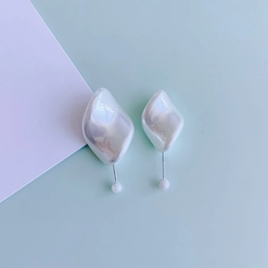 French vintage style irregular pearl earrings with silver posts on mint green background