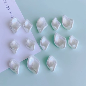 Macro shot of irregular pearl white jewelry accessories with glossy glaze on blue background