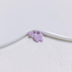 Vue macro d'un pendentif cœur en alliage lavande avec finition mate et anneau de suspension