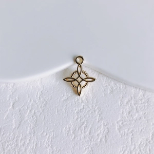 Détail d'un pendentif en métal doré en forme d'étoile avec texture perlée délicate