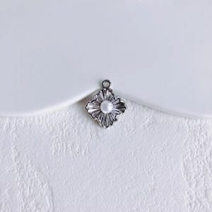 Detail van een stervormige zilveren hanger met centrale parel voor DIY sieraden