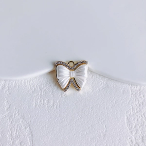 Detail van vlinderhanger met wit emaille en kristallen rand voor DIY-sieraden maken