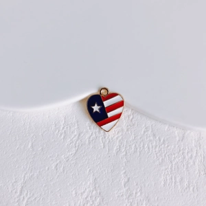 Close-up of heart-shaped American flag charm with white star on a white stone base