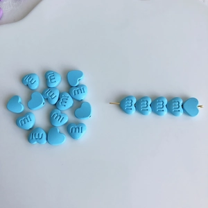 Nahaufnahme blauer herzförmiger Bastelperlen mit mi-Gravur für DIY-Haarschmuckzubehör