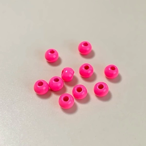 Vista macro de cuentas redondas fucsia brillantes para joyería DIY y collares artesanales
